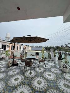 a patio with a table and chairs and an umbrella at Compostela Guest Room #2 Terrace, Rooftop, Netflix, WiFi in Compostela +13 photos