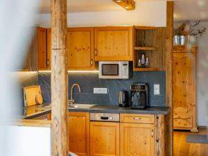 a kitchen with wooden cabinets and a sink and a microwave at Tauernapart in Mittersill +27 photos