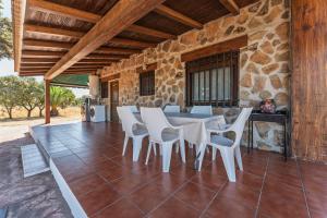 a dining room with a table and white chairs at Casa con piscina Jailás in Valverde de Mérida