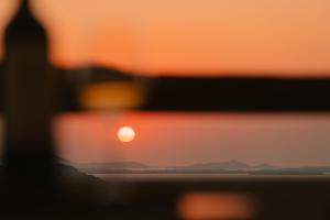 a close up of the sun setting over the ocean at Naxos Tower in Naxos Chora