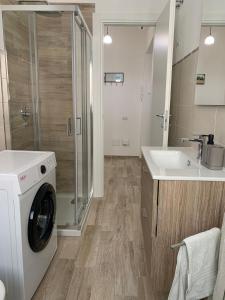 a bathroom with a washing machine and a sink at ivyhouse in Minturno
