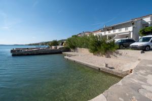 a body of water with cars parked next to it at Rooms by the sea Metajna, Pag - 6378 in Metajna
