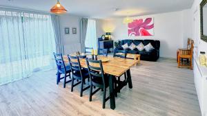 a dining room with a wooden table and blue chairs at Eden Gateway full equipment brand new bright and modern En-suite Double bedroom - room 3 near city centre in Birmingham