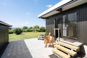 a patio with a bench and a table and chairs at 8220-Vordingborg-Solbaervej-6 in Vordingborg