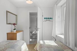 Biała sypialnia z 2 łóżkami i łazienką w obiekcie 4167-Borre-Klintholm-Havneby-67 w mieście Borre +23 zdjęcia