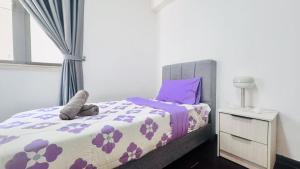 een slaapkamer met een bed met paarse lakens en een raam bij 富力公主湾R&F Princess Cove by RongYu in Johor Bahru