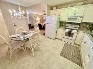 a kitchen with a table with chairs and a white refrigerator at Coastal Adorable 2 Bedroom 1 Bath Beach Bungalow On Nettle Island Resort N1184 in Jensen Beach