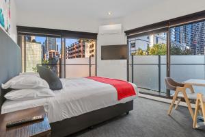 a bedroom with a bed and a large window at Comfort Apartments on Elizabeth in Melbourne +39 photos