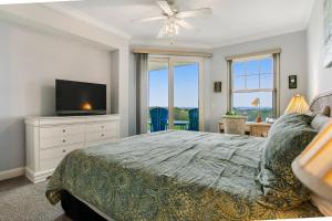 Un dormitorio con una cama y un televisor de pantalla plana. en Luxe, Updated, Oceanfront Condo with Ground-Floor Patio, WiFi & Shared Pool, en Amelia Island