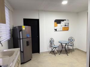a kitchen with two chairs and a table and a refrigerator at Apartamento Opaa in San Andrés