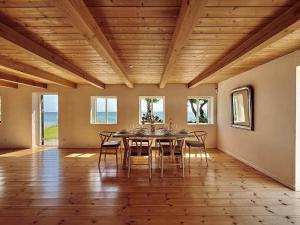 Un comedor con techo de madera, mesa y sillas. en 6040-Stege-Rytsebaekvej-39, en Stege