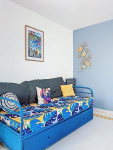 a blue couch with colorful pillows in a room at Studio Coin Du Bonheur in Saint-François +14 photos