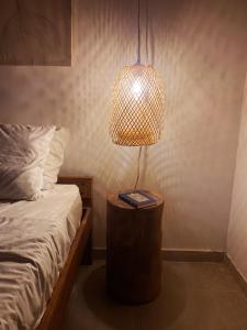a lamp on a table next to a bed at La Granja De Bam Bam in Sasaima