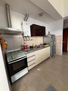 una cocina con estufa y refrigerador en Lomas, en Santiago del Estero