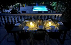 a table with candles and plates and lights on it at Two-Bedroom Holiday Home In Sibenik in Šibenik +25 photos