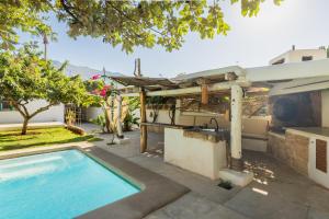 a swimming pool with a pergola next to a house at Latidos del mar in Denia