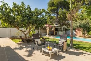 a patio with chairs and a table next to a pool at Latidos del mar in Denia