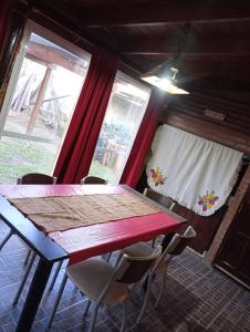 una sala da pranzo con tavolo e sedie rossi di Cabañas Los Abuelos a Santa Rosa de Calamuchita Altre 9 foto
