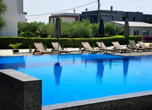 a large swimming pool with chairs and umbrellas at Lula Apartments in Ulcinj