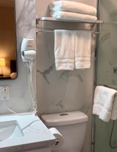 a bathroom with a toilet and a sink and towels at Flushing City Escape in Flushing