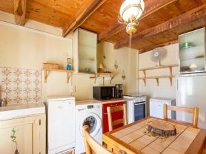a kitchen with a washer and dryer and a table at Cevennes Stone Retreat in Saint-Germain-de-Calberte