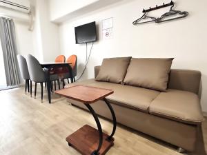 a living room with a couch and a table at Lucky NAMBA 大阪難波 なんば in Osaka