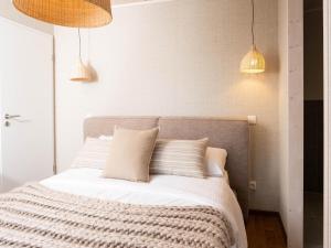 a bedroom with a bed with white sheets and pillows at Vacation House near Tournai in Award-Winning Park in Antoing