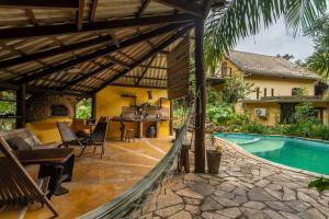 an outdoor patio with a swimming pool and a house at Cantos da Mata in Chapada dos Guimarães