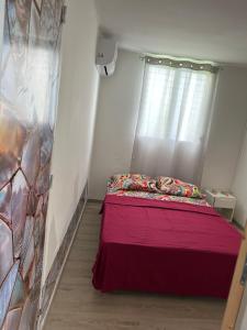 a bedroom with a red bed with a window at Dolce Vita Emilia in Sainte-Luce