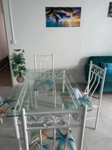 a glass table and chairs in a living room at Dolce Vita Emilia in Sainte-Luce +1 photo