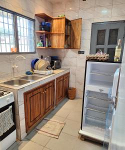 a kitchen with a sink and a refrigerator at Cité MOPKOPKO in Komé +5 photos
