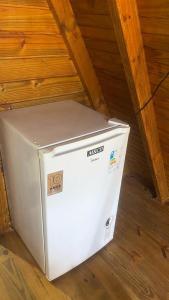 un frigorifero bianco appoggiato sul pavimento di una soffitta di Pousada Vale das Pedras 03 a Pedras Grandes Altre 4 foto