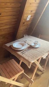 un tavolo con due piatti e bicchieri sopra di Pousada Vale das Pedras 03 a Pedras Grandes