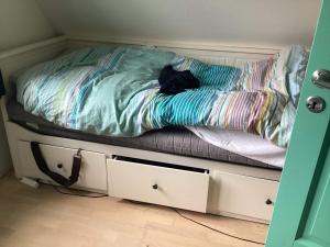 a unmade bed in a room with white drawers at 4 star holiday home in Humlebæk in Humlebæk