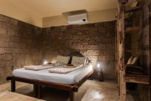 a bedroom with a bed in a brick wall at Cantos da Mata in Chapada dos Guimarães