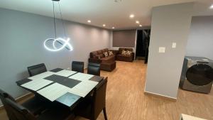 a dining room with a table and a living room at Cozy Modern 3 Bedroom Apartment in Guatemala City in Santa Rosita