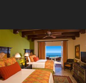 Montecristo Villa at Quivera Los Cabos Vacation Rental في كابو سان لوكاس: غرفة نوم بسريرين وإطلالة على المحيط