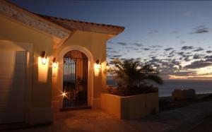 Montecristo Villa at Quivera Los Cabos Vacation Rental في كابو سان لوكاس: مبنى به بوابة مطلة على المحيط
