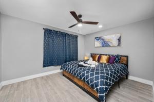a bedroom with a bed and a ceiling fan at Bright and Airy 2BR with King Bed Free Parking and Pool in Houston