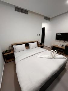 Un dormitorio con una cama grande con sábanas blancas. en Aryaf Hotel Apart Tabasum Group, en Ajman