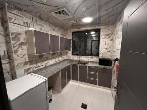 アジュマーンにあるAryaf Hotel Apart Tabasum Groupのキッチン(グレーのキャビネット、カウンタートップ付) +31枚の写真