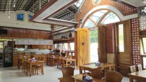 a restaurant with wooden tables and chairs in a room at Harmony Resto & Homestay in Ngadisari