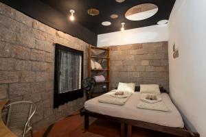 a room with a bed and a brick wall at Cantos da Mata in Chapada dos Guimarães