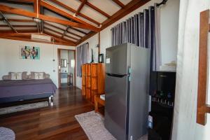 a kitchen with a refrigerator and a bed in a room at La Bima Beach House in Sekongkang Bawa
