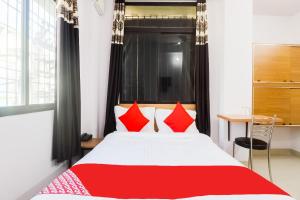 a bedroom with a large bed with red pillows at Hotel O Dream Inn in Patna +20 photos