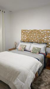 a bedroom with a large bed with white sheets and pillows at Flor de Lis in Puerto Iguazú
