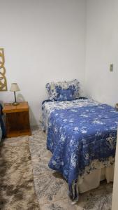 a bedroom with a bed with a blue comforter at Flor de Lis in Puerto Iguazú