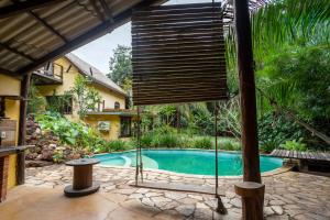 a swing in front of a house with a swimming pool at Cantos da Mata in Chapada dos Guimarães +45 photos