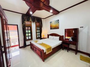 a bedroom with a bed and a desk in it at PhaiLin Hotel in Luang Prabang