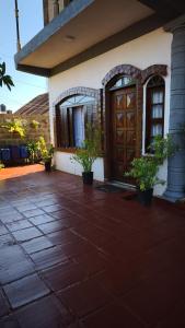 a house with a patio with a wooden door at Flor de Lis in Puerto Iguazú